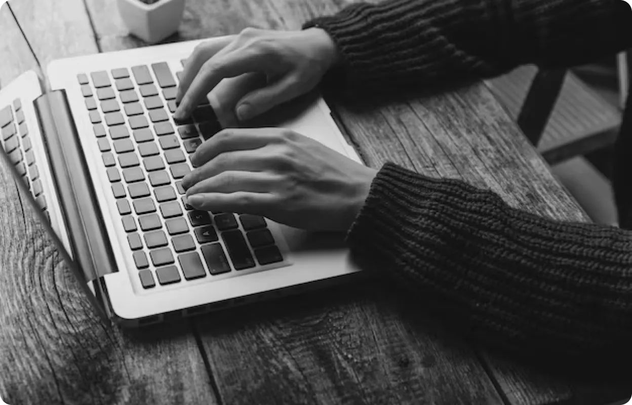 Hands typing on laptop