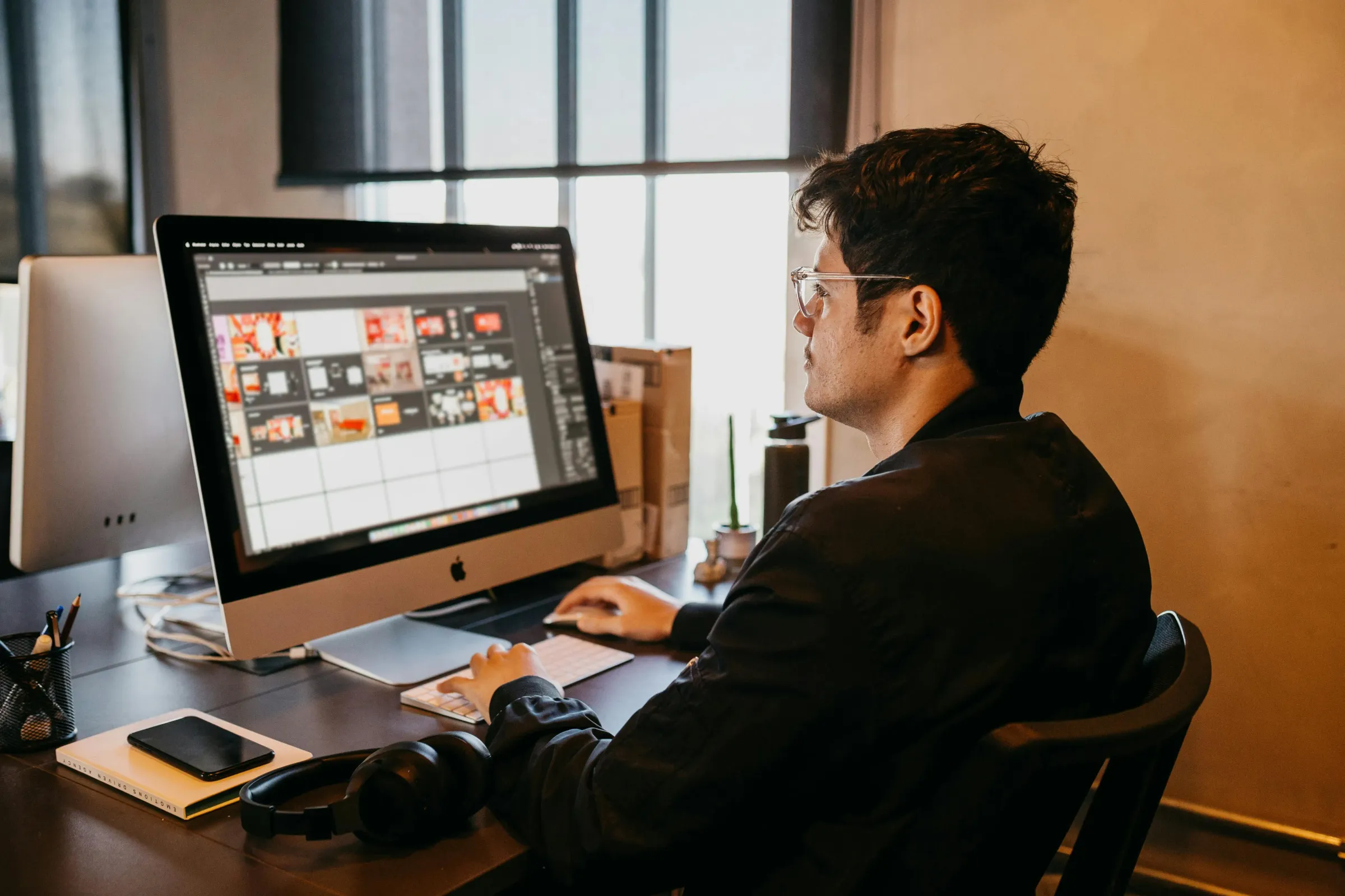 Developer working at desk with Apple monitor