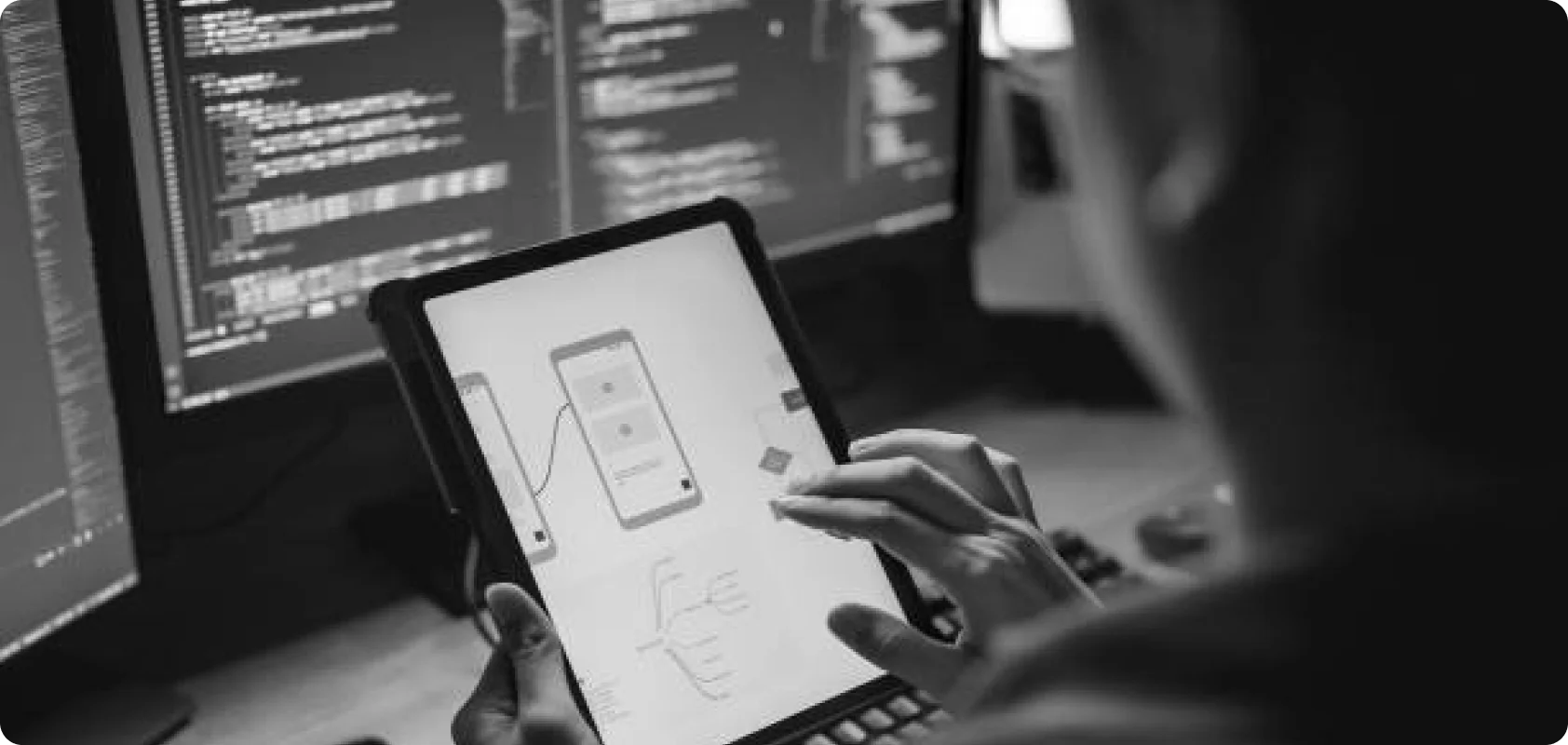 Two women collaborating and looking at laptop code