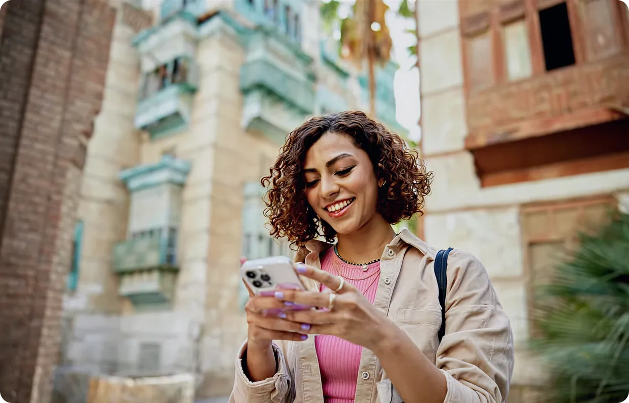 Woman shopping on mobile in colorful marketplace